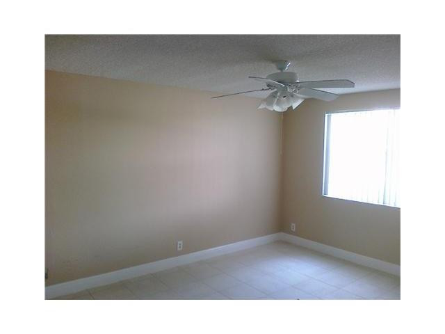 8977 Wiles Road, Unit 2105 Coral Springs, FL 33067 - Photo 4 of 7 a picture of a room with a ceiling fan and a window