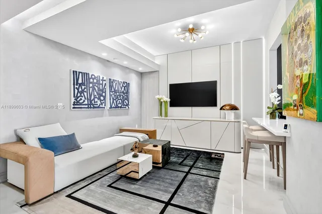 a living room with furniture a flat screen tv and a chandelier