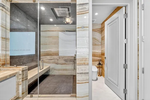 a bathroom with a granite countertop shower a sink and a mirror