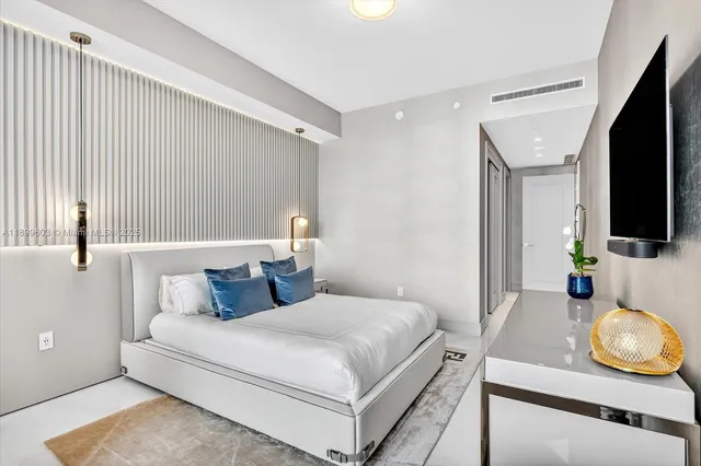 a bedroom with a bed and flat screen tv