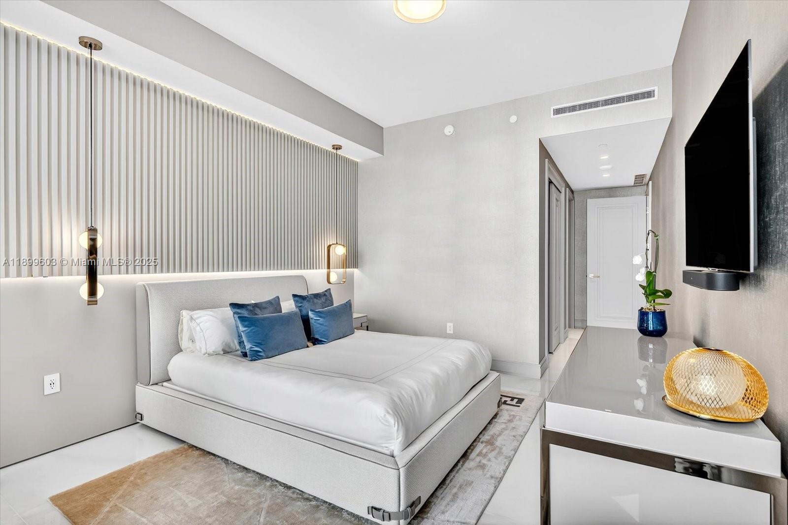 17901 Collins Avenue, Unit 3103 Sunny Isles Beach, FL 33160 - Photo 27 of 38 a bedroom with a bed and flat screen tv