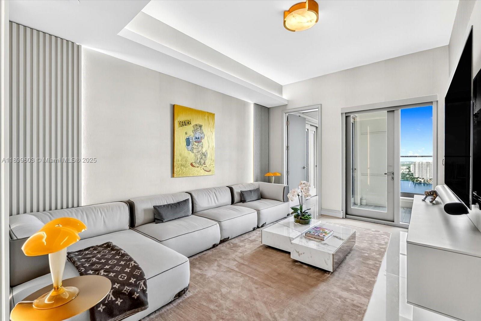 17901 Collins Avenue, Unit 3103 Sunny Isles Beach, FL 33160 - Photo 29 of 38 a living room with furniture and a flat screen tv