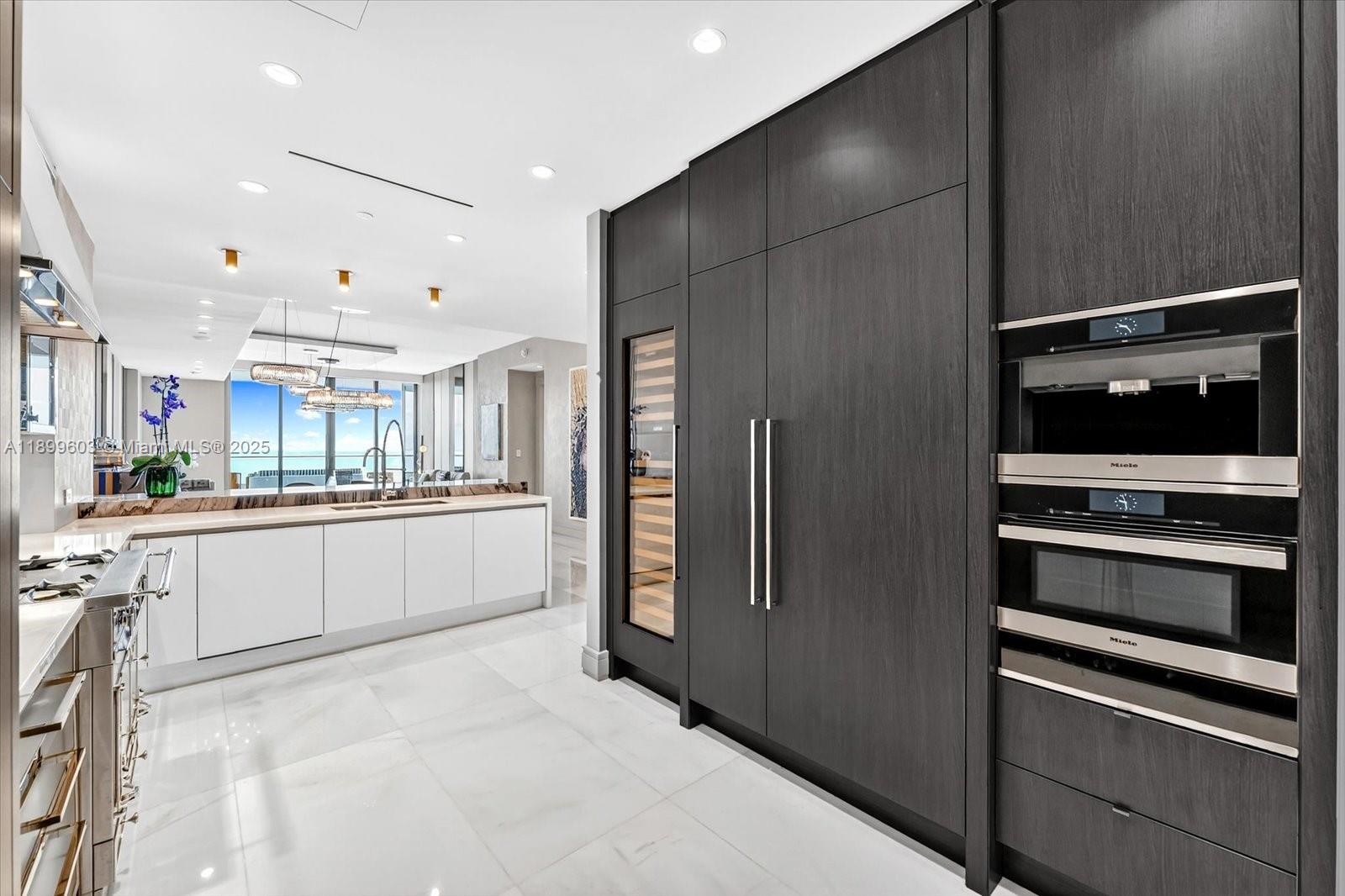 17901 Collins Avenue, Unit 3103 Sunny Isles Beach, FL 33160 - Photo 9 of 38 a large white kitchen with a refrigerator and a stove