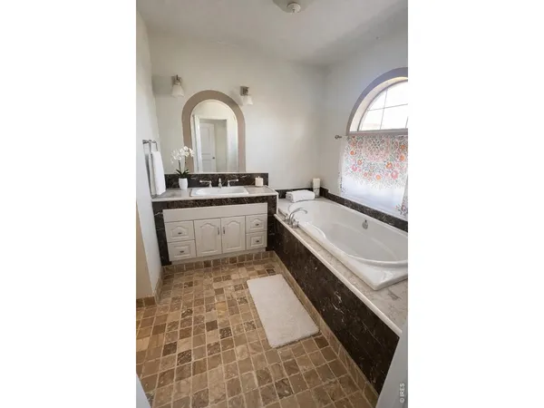 a large white kitchen with sink a stove and a window