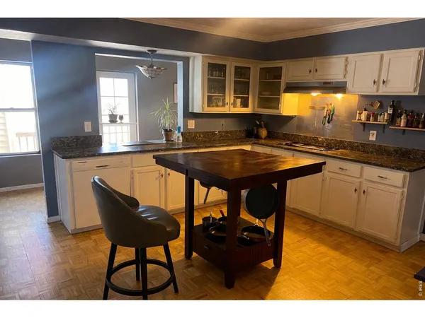 a kitchen with a table chairs and wooden cabinets