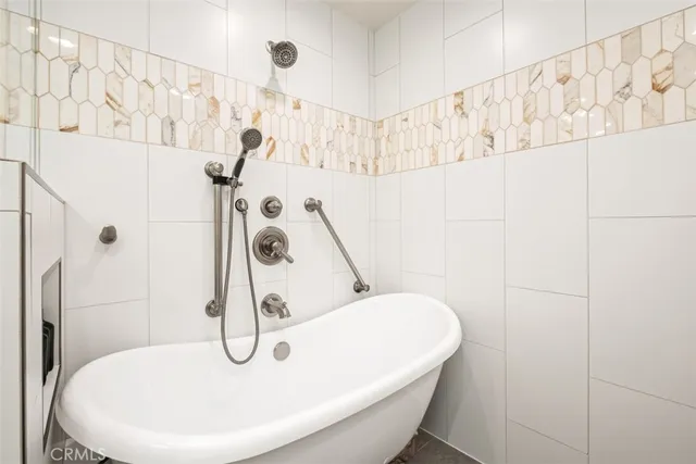 a bathroom with a white bathtub and shower