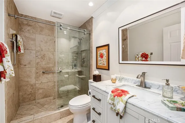 a bathroom with a granite countertop sink toilet and shower