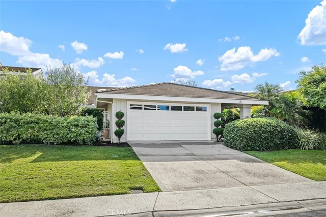 a front view of a house with a yard and potted plants