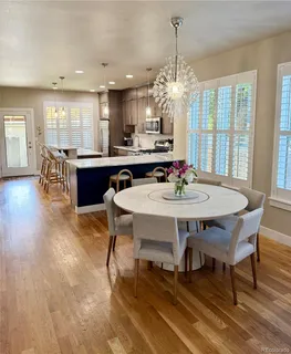 a dining room with furniture a chandelier and wooden floor