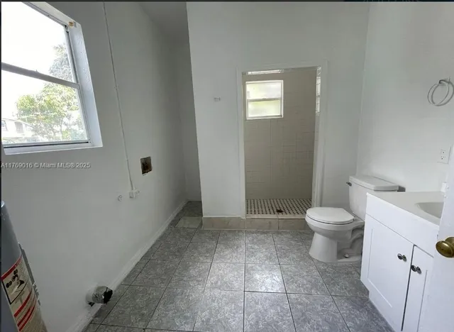 a bathroom with a toilet a sink and a window