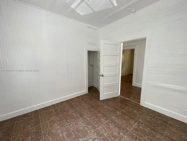 an empty room with closet and mirror