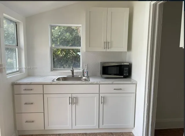 a kitchen with white cabinets and a sink