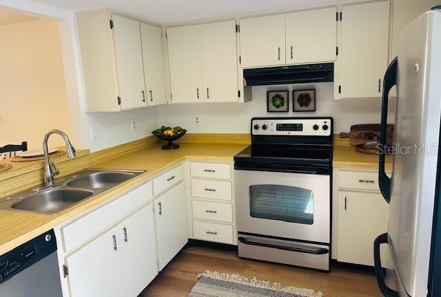 2033 Hawkhurst Circle, Unit 180 Sun City Center, FL 33573 - Photo 7 of 19 a kitchen with white cabinets and white appliances