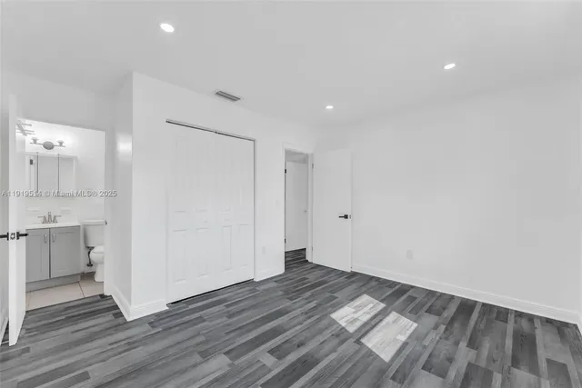 a view of a room with wooden floor and white walls