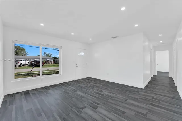 a view of a room with wooden floor and a window