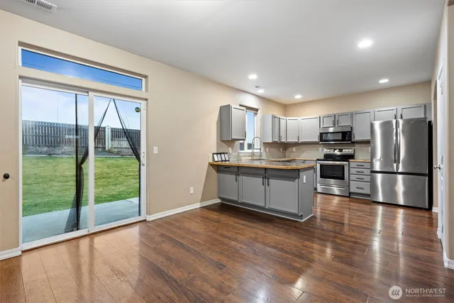 a kitchen with stainless steel appliances granite countertop a refrigerator and a stove top oven