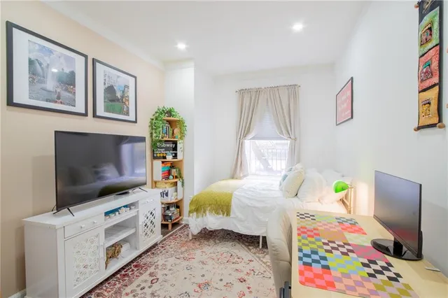 a bedroom with a bed and a flat screen tv