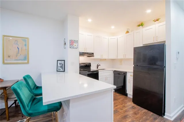 a kitchen with a refrigerator a stove a sink a dining table and chairs