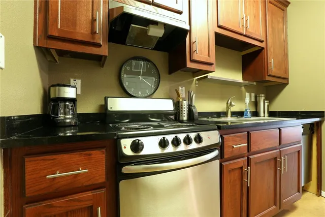 a kitchen with stainless steel appliances granite countertop a stove and a microwave