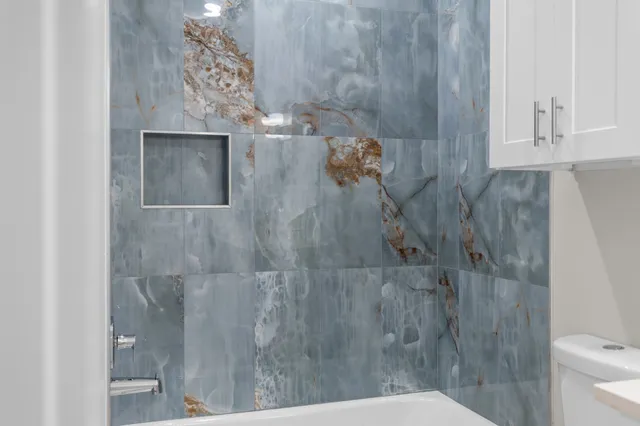 a bathroom with a toilet and a shower