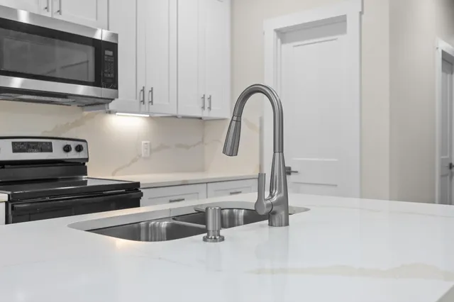 a kitchen with stainless steel appliances granite countertop a sink a microwave and cabinets