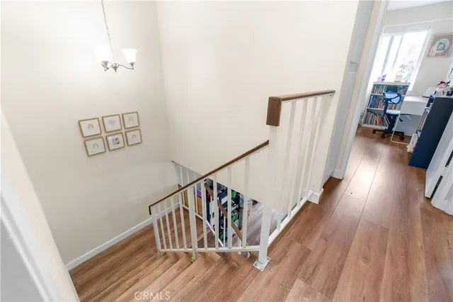 a view of a hallway with wooden floor and stairs