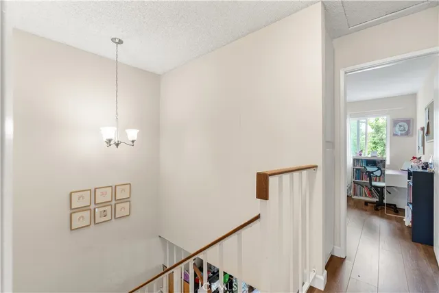 a view of a hallway with workspace and wooden floor
