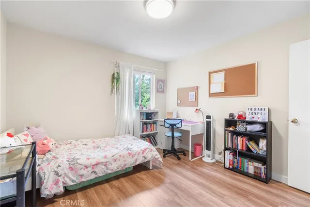 a bedroom with a bed a table and a book shelf