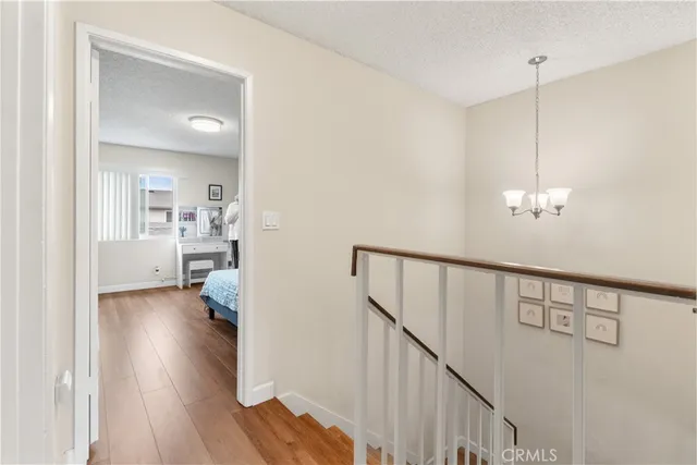 a view of a hallway with wooden floor and a livingroom