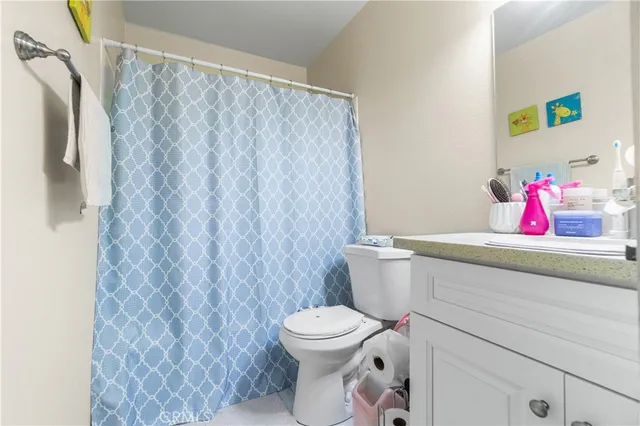 a bathroom with a toilet and a shower curtain