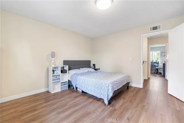 a bedroom with a bed and wooden floor