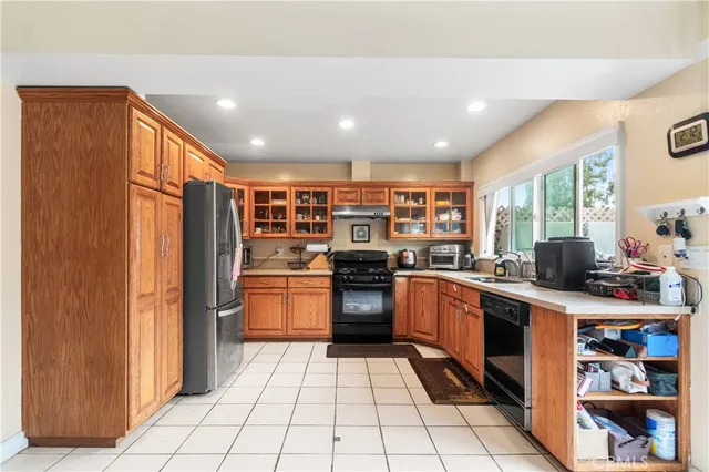 a kitchen with stainless steel appliances granite countertop a refrigerator and a stove top oven