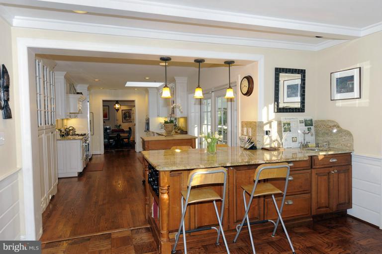 7720 Greentree Road Bethesda, MD 20817 - Photo 2 of 23 a dining hall with stainless steel appliances kitchen island granite countertop a table chairs and a refrigerator