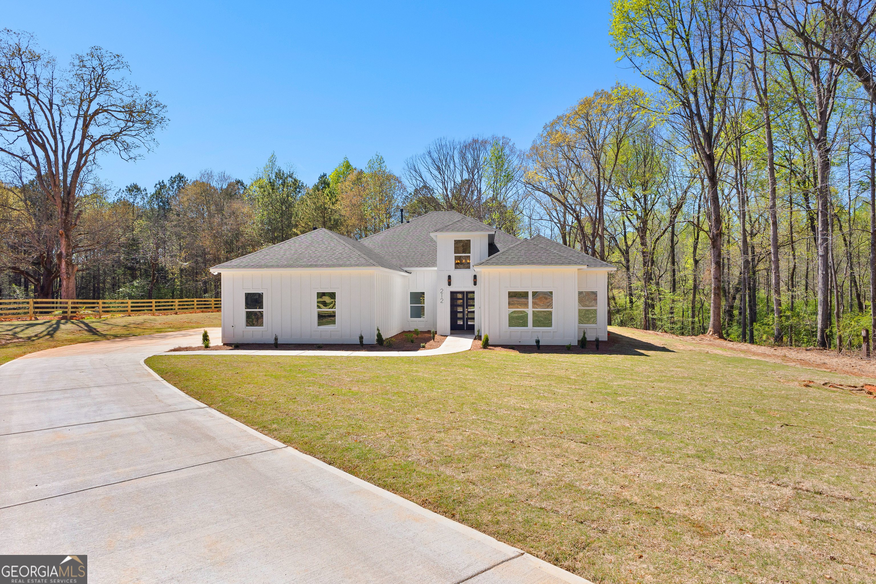 a front view of a house with a yard and trees
