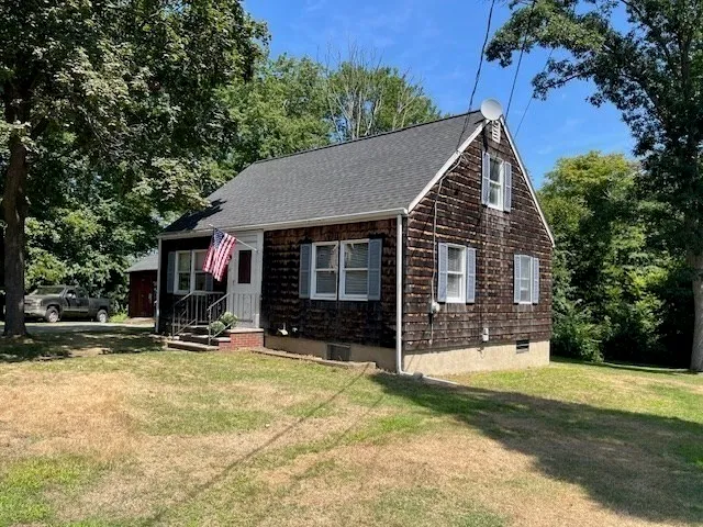 a view of house with yard and sitting area