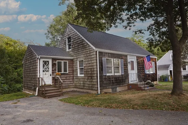 a view of a house with a yard and large tree