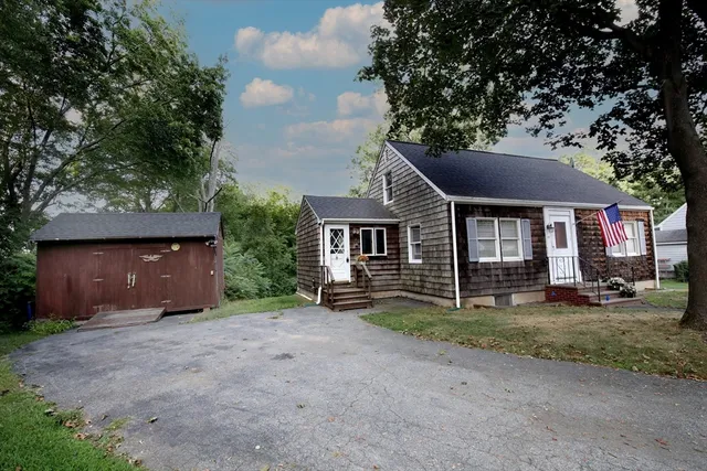 a front view of a house with a yard and trees