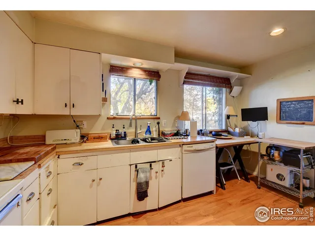a kitchen with a sink a stove cabinets and a dining table