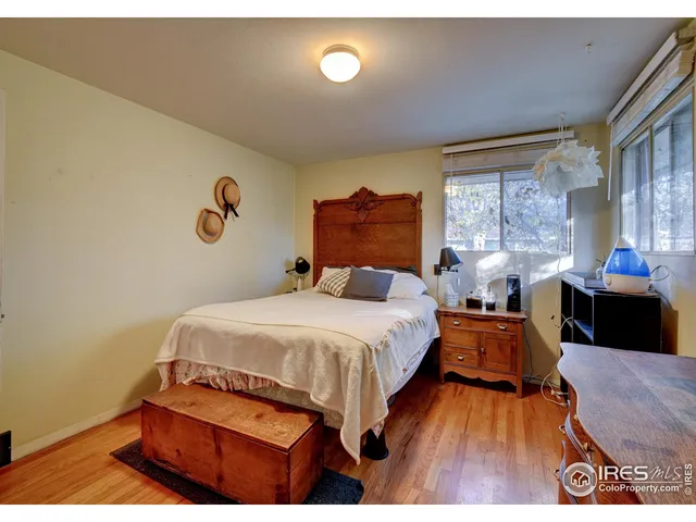a bedroom with a bed and dresser with mirror