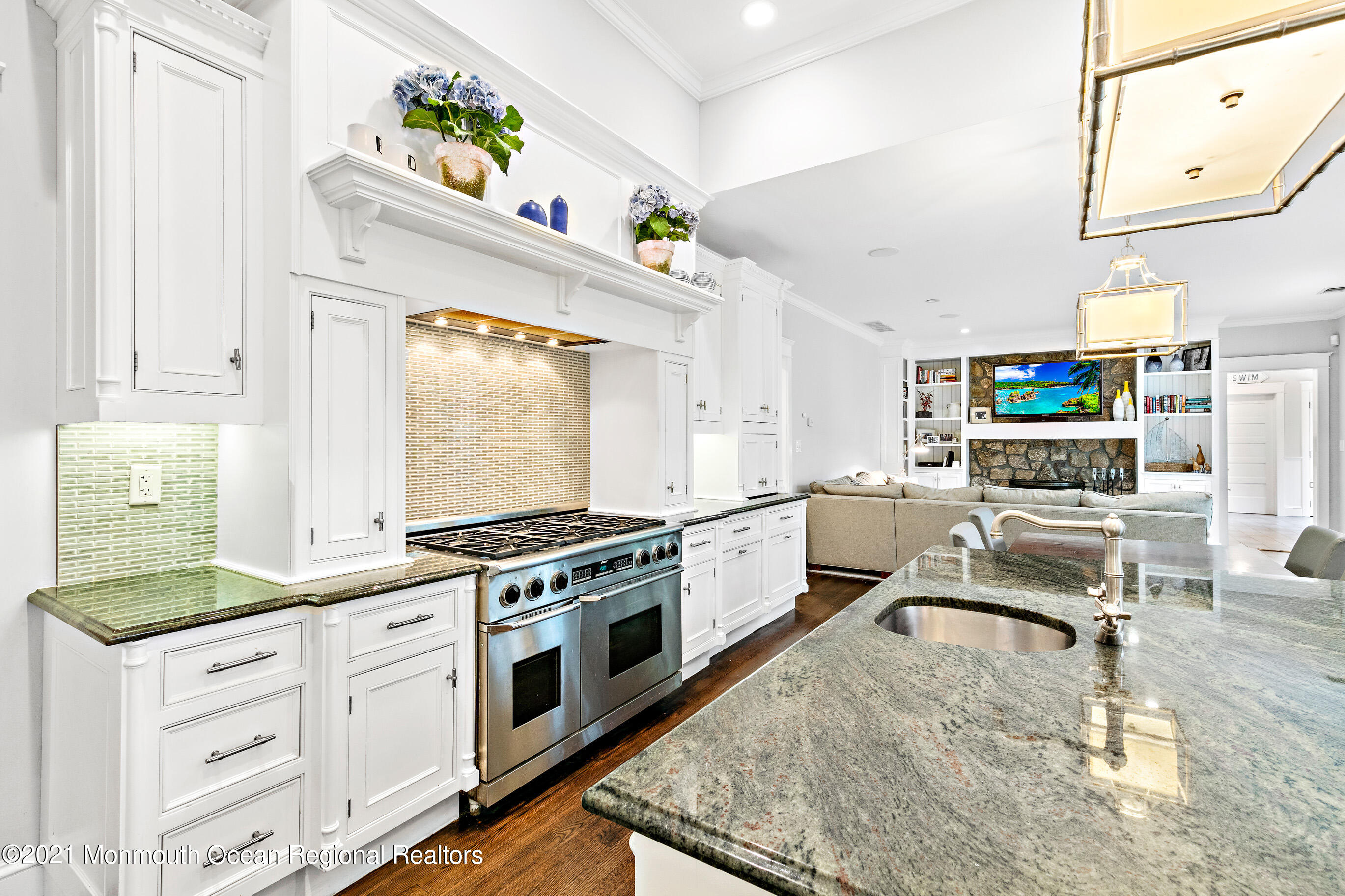 43 Muhlenbrink Road Colts Neck, NJ 07722 - Photo 18 of 89 a kitchen with stainless steel appliances granite countertop a stove top oven a chimney a dining table and chairs with wooden floor