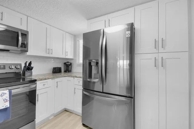 a kitchen with stainless steel appliances refrigerator and microwave