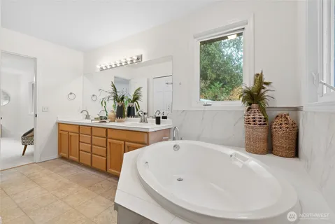 a spacious bathroom with a tub sink and mirror
