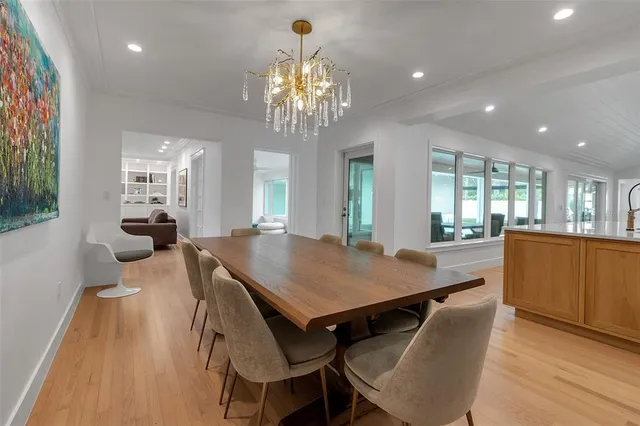 a kitchen with stainless steel appliances granite countertop a stove top oven a sink a dining table and chairs