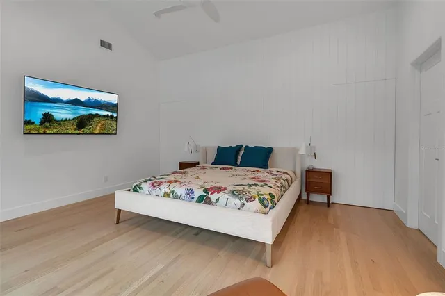 a bedroom with a bed and wooden floor