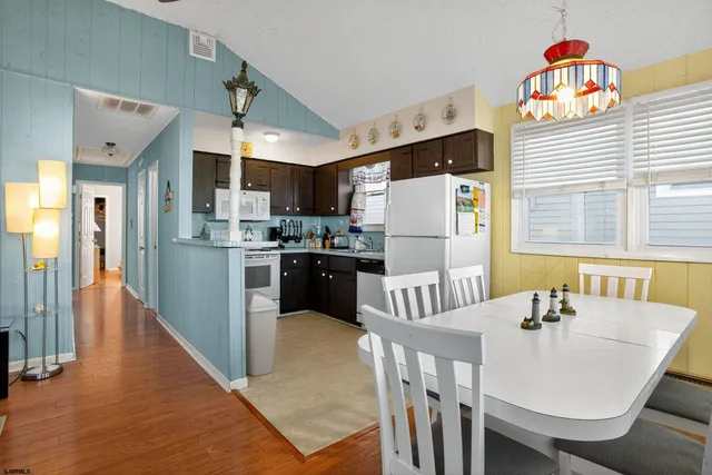 a kitchen with stainless steel appliances a refrigerator a stove a dining table and chairs
