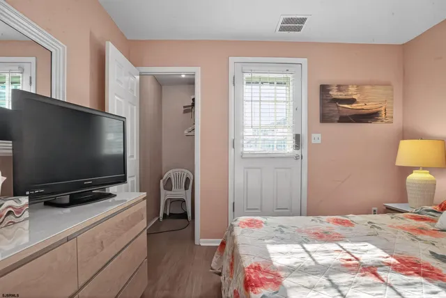 a bedroom with bed and a flat screen tv