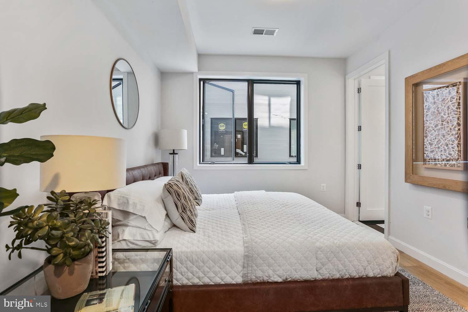 2248 Ontario Road Northwest, Unit 5 Washington, DC 20009 - Photo 23 of 30 a bedroom with a bed mirror and window