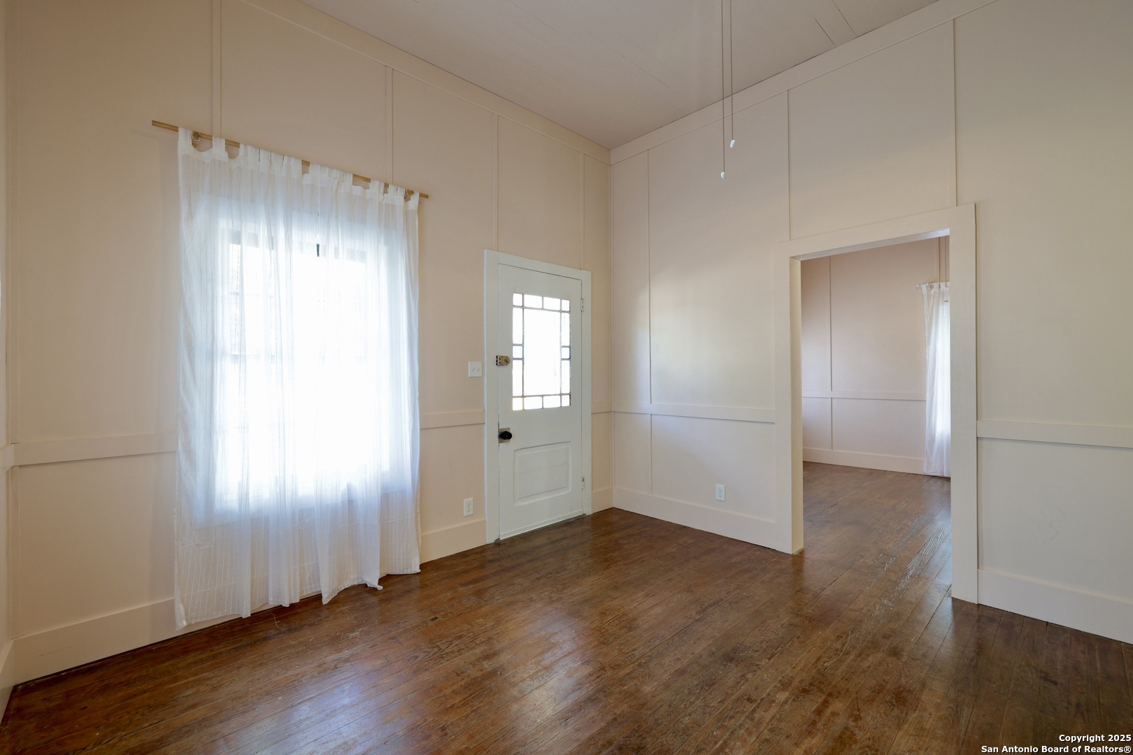 410 Riddle Street San Antonio, TX 78210 - Photo 12 of 22 an empty room with wooden floor and windows