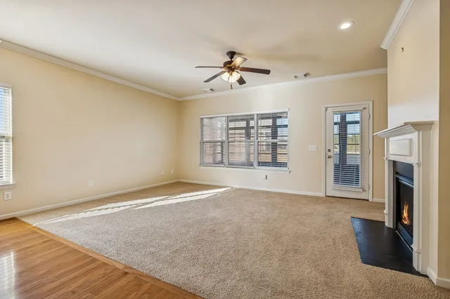 a view of an empty room with a fireplace and a window