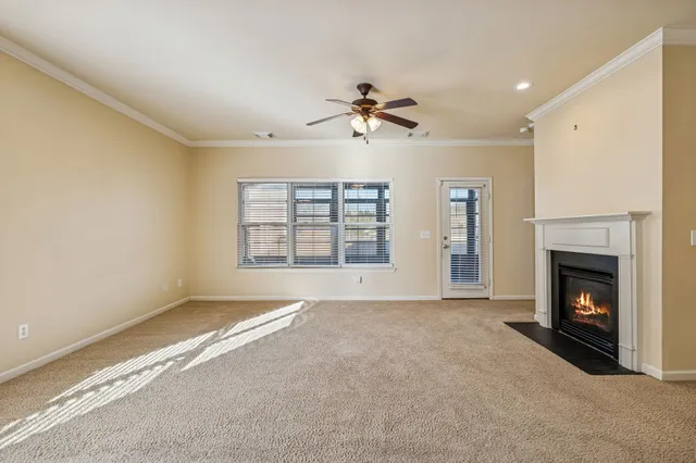 a view of an empty room with a fireplace and a window